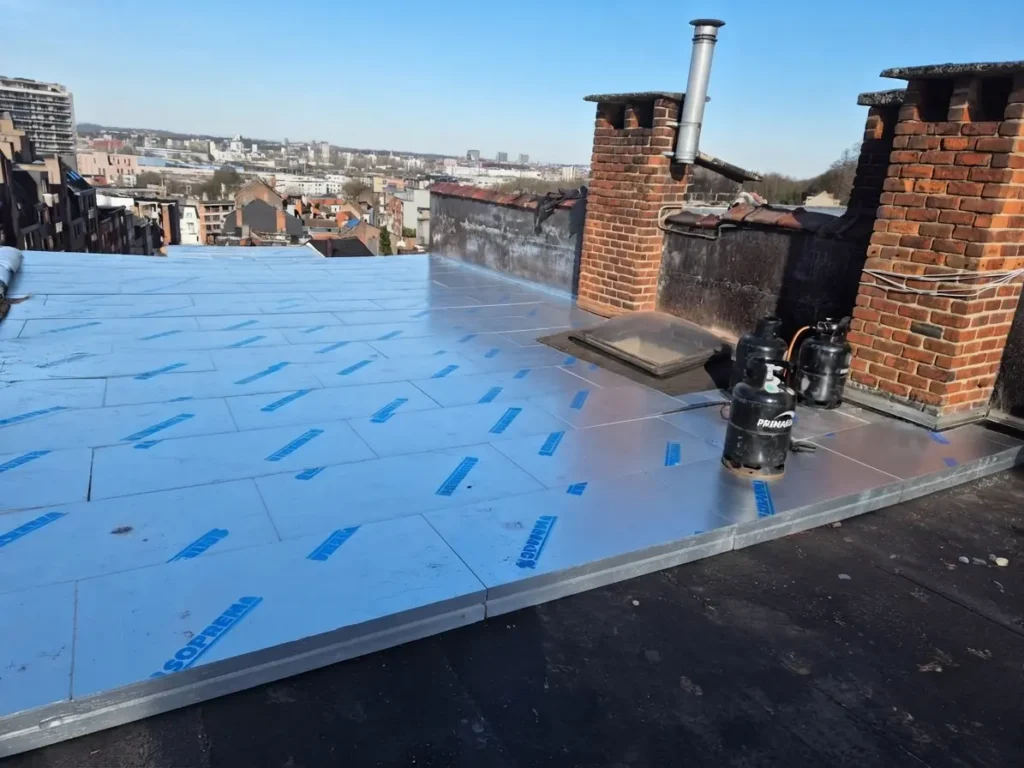 Pose de panneaux isolants sur une toiture plate en rénovation à Evere