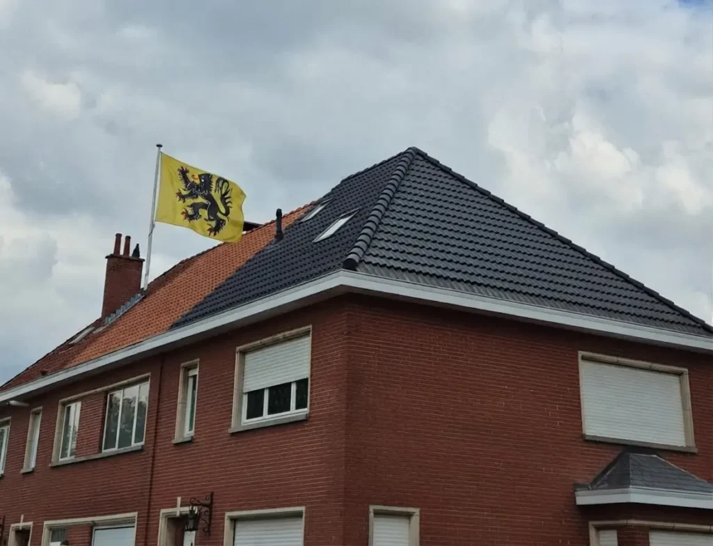 Rénovation complète de toiture inclinée avec tuiles noires et drapeau flamand dans le Brabant flamand