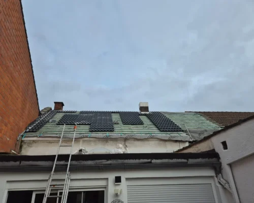 Rénovation de toiture en cours (pendant travaux) à Woluwe-Saint-Lambert (Bruxelles), avec pose de nouvelles tuiles et remplacement de fenêtres de toit.